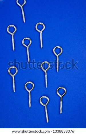 Pattern of hook screws on blue background
