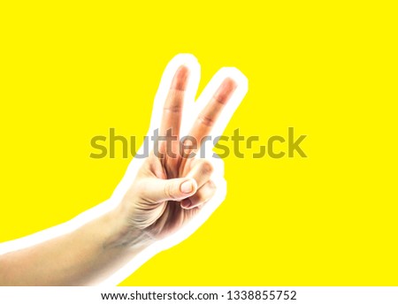Hand symbol shows thumb up sign isolated on yellow background. magazine style collage. The palm of the fingers of female hands show the symbol of the signs.