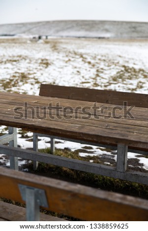 Empty wooden table with snow bokeh for a catering or food background