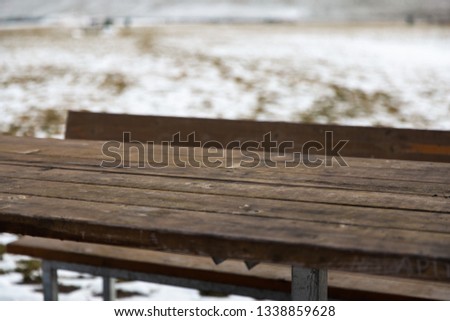 Empty wooden table with snow bokeh for a catering or food background