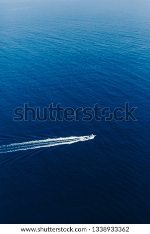 Yacht at the sea in Italy. Aerial view of luxury floating boat on transparent turquoise water at sunny day. Summer seascape from air. Top view from drone. Seascape with motorboat in bay.