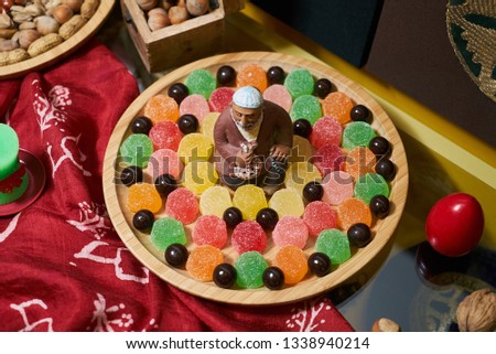Novruz Azerbaijan traditional table with food tray, close-up. Delicious sweet pastry and dry fruits on a wooden plate 