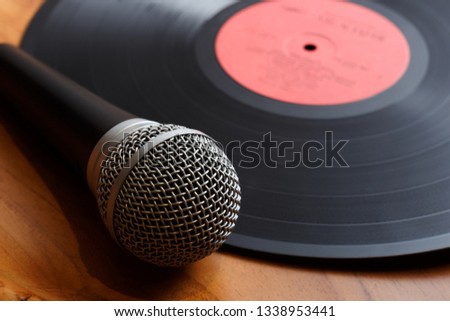 Vintage old vinyl record with microphone on a wooden background. Royalty-Free Stock Photo #1338953441