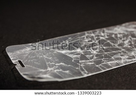 Broken screen of a phone isolated on the black background. Need to repair and fix concept. Crashed phone glass cover close up view.