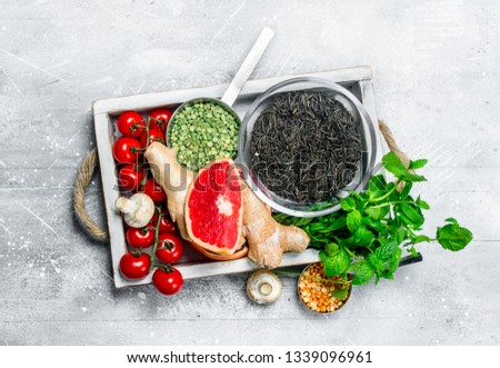 Healthy food. Different organic fruits and vegetables with black rice in wooden box. On a rustic background.