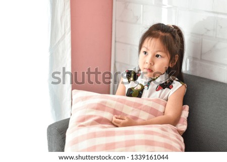 Beautiful portrait Asian little girl relaxing on couch in living room 