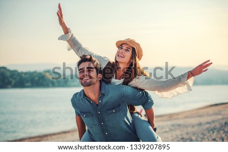 Summer time. Beautiful young couple enjoying in a good mood on the beach. Lifestyle, love, dating, vacation concept Royalty-Free Stock Photo #1339207895