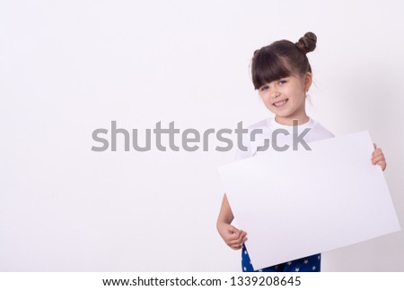 Young girl with white blank. Advertising place for you, empty card, cute kid holding it.