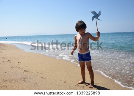 Child playing pinwheel, Beach summer holiday concept, Selective focus