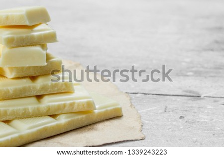 White chocolate on paper. On a rustic background.