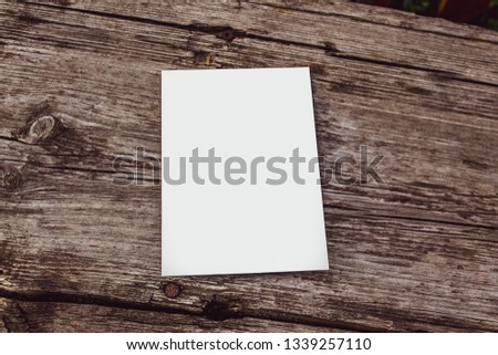Mock up card, post card or advertising leaflet of standard A5 size on dark wood texture background

