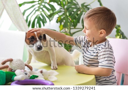 Cute little boy with funny dog at home