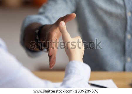 Close up African American businessman shaking hand of candidate at job interview, hiring process, greeting business partner at meeting, making agreement, signing contract, partnership concept Royalty-Free Stock Photo #1339289576