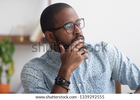 Pensive African American businessman pondering business strategy, serious employee thinking about project, problem solution, looking in distance, puzzled manager making decision, close up Royalty-Free Stock Photo #1339292555