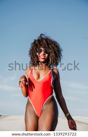 Beautiful afro american woman sticking out tongue in the street. Rebel expression