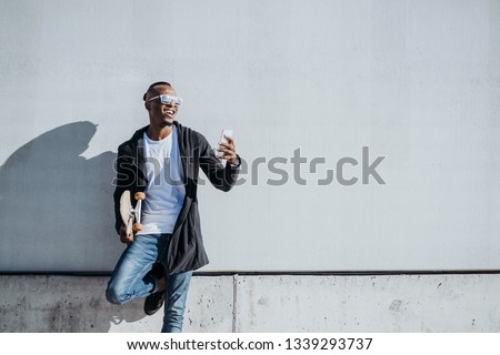 African young man using mobile in the street.