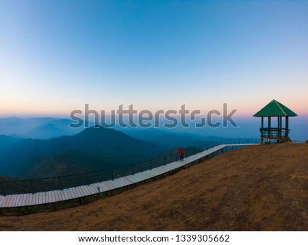 Scenic landscape, Lonely pavilion against a blue sky during morning with a tourist taking a picture on corridor on the hill at Doi pui co moutain view point in Sop Moei, Mae hong son, Thailand.