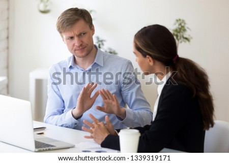 Funny businessman rejecting to give interview to journalist. Stop sign. Man from recruitment management stopping interviewing lady, fraud, unhappy customer complaining, demanding compensation Royalty-Free Stock Photo #1339319171