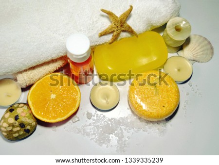 Spa composition of organic orange skin and hair care products of  mood-enhancing  and vitaminizing action with handmade dry shampoo, soap, citrus shampoo, towels, seashells, candles, orange slice.  