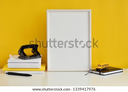 Student work place with black and yellow office supplies, books, school bus toy, white frame mock up.