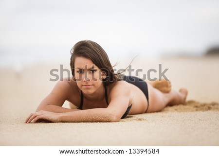 Bikini girl laying down relaxing on beach