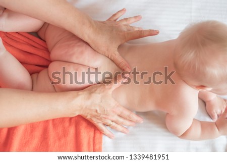 Doctor pediatric terapist a back and lumbar phisical massage to the newborn child for proper body shaping and body development. Baby back massage Royalty-Free Stock Photo #1339481951