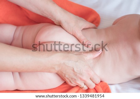 Doctor pediatric terapist a back and lumbar phisical massage to the newborn child for proper body shaping and body development. Baby back massage Royalty-Free Stock Photo #1339481954