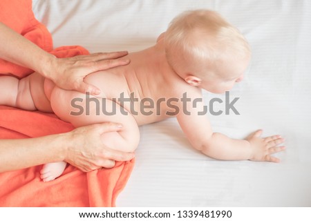 Doctor pediatric terapist a back and lumbar phisical massage to the newborn child for proper body shaping and body development. Baby back massage Royalty-Free Stock Photo #1339481990