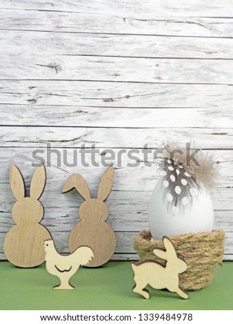 Easter background with Easter egg, Easter bunnies  and cock isolated on green in front of wood