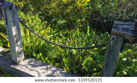 Rope gate across overgrown path