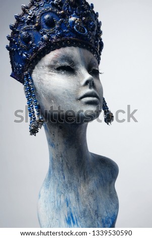 Head of woman mannequin in blue decorated kokoshnick, grey studio background