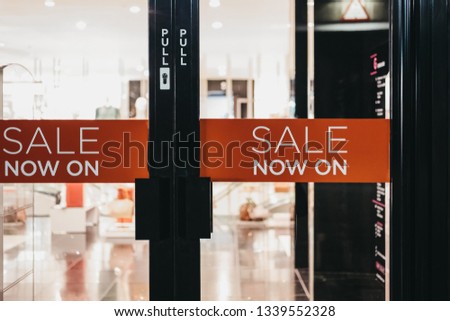 Sales now on sign on an entrance door to a shop, selective focus.