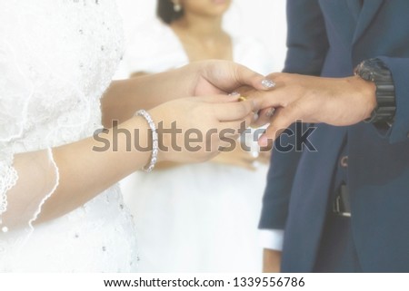 Bride Put the Wedding Ring to Her Groom in the Wedding Ceremony. Vintgae Style Picture with Gain Added.