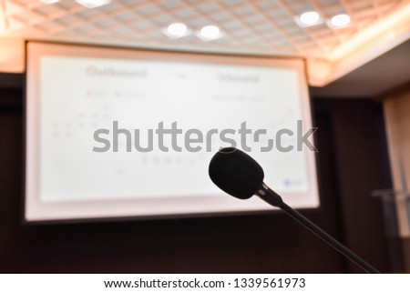 Close up Microphone with presentation slide show on projector screen background in meeting room