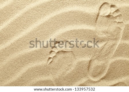 Footprints in the sand waves as background