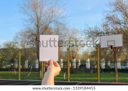 Mock up card, post card or advertising leaflet of standard A5 size on on the background of the sports field with a basketball ring