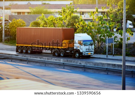 Container trucks are parked beside the roadside.