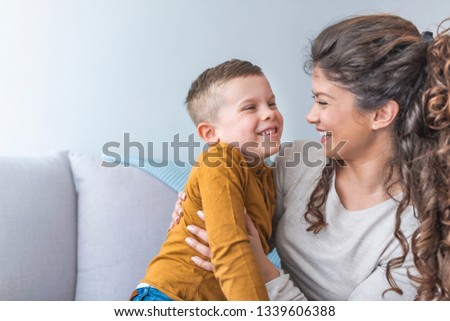 Family. Beautiful mother and her cute son. Young mother with her 6 years old little son are relaxing and playing in the bed at the weekend together, lazy morning, warm and cozy scene.
