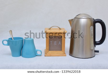 Mockup / design set of colorful Tea or coffee ceramic mug beside wooden tea kitchen box and stainless steel kettle .  template for branding identity and company logo design/ drink-ware, Dining 