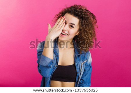 beautiful curly girl fooling around on a pink background