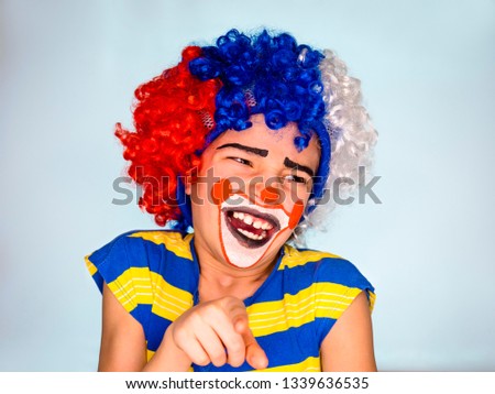 Handsome little boy Laughs and Points Finger. little cute boy with facepaint like clown, pantomimic expression. emotions. April Fool's Day, April 1