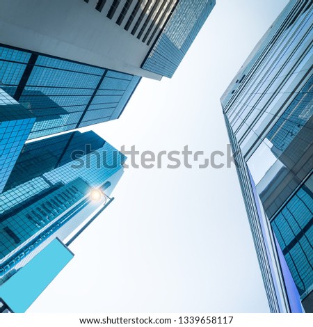 Abstract futuristic cityscape view with modern skyscrapers. City lantern with empty advertisement banner under blue sky at sunny day. Urban architecture background. Hong Kong