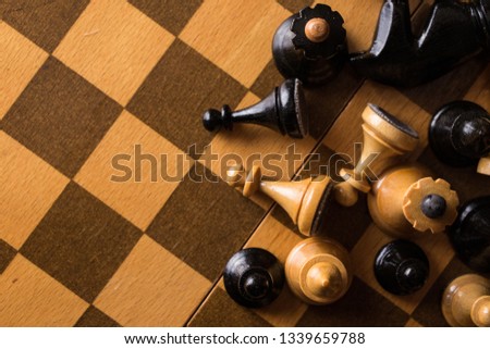 Chess pieces on a wooden chessboard  background.