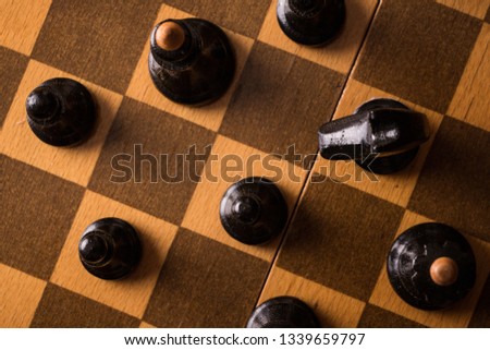 Chess pieces on a wooden chessboard  background.