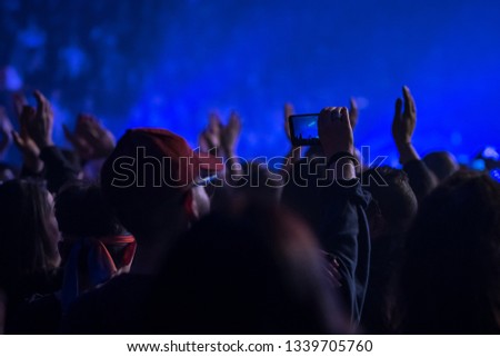 many people who dance and record with the phones at the live music concert