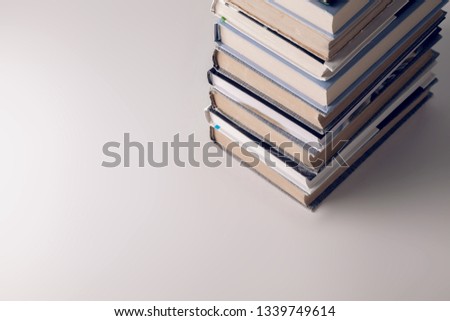A stack of old and new books on a white-gray background.