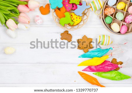 Child hands decorating honemade gingerbread with icing sugar using a pipping bag. Easter Treats. Handmade cookies, standing on the table. series of step by step photos. Royalty-Free Stock Photo #1339770737
