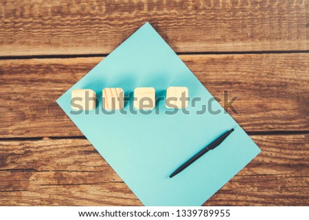 wooden cubes with pen on blue paper 