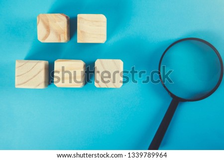 wooden cubes with magnifier on the blue background
