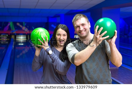 Happy couple in a bowling alley having fun